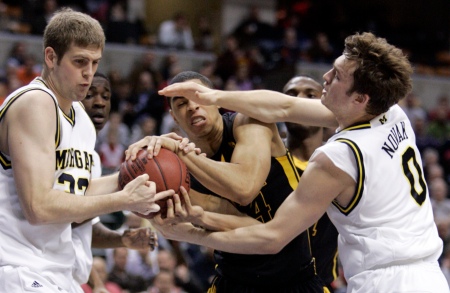 Iowa forward Aaron Fuller, center, battles to maintain control of the ball against Michigan forward Zack Gibson, left, and guard Zack Novak during the first half at the Big Ten men's tournament March 12, 2009 in Indianapolis. (AP Photo/Michael Conroy)