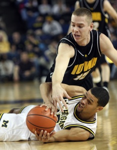 Michigan guard David Merritt, bottom, contests for the ball with Iowa guard Devan Bawinkel, top, in the second half of an NCAA college basketball game, Sunday, Jan. 11, 2009, in Ann Arbor, Mich. Michigan won 64-49. (AP Photo/Tony Ding)
